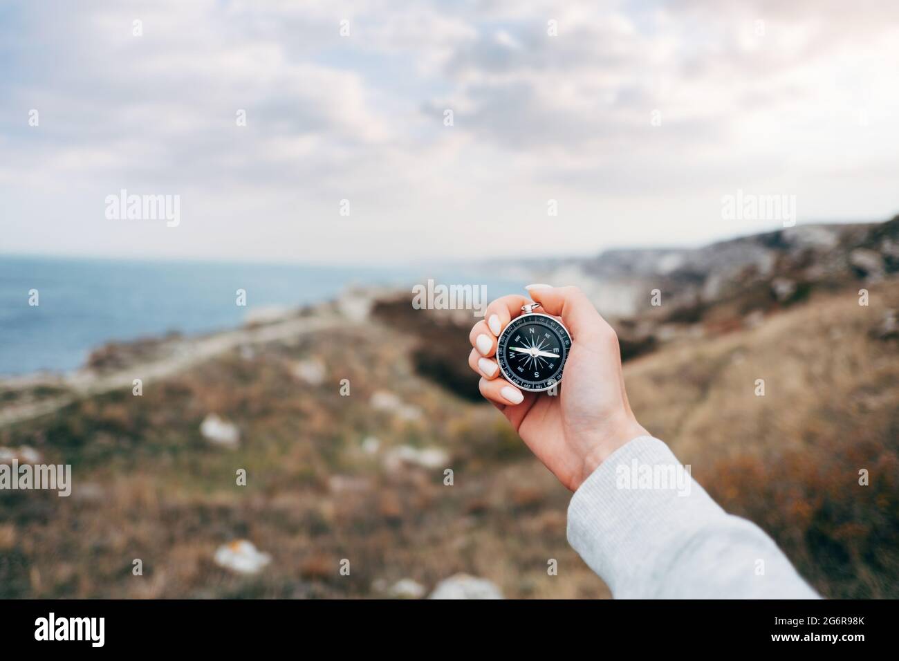 Donna escursionista con una bussola si orienta in una zona montagnosa. Foto Stock