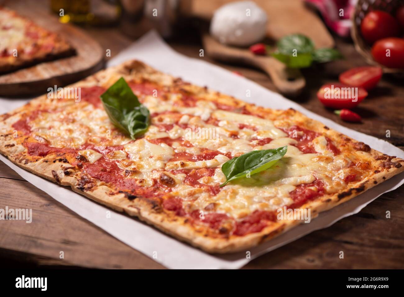 Pizza fatta in casa a forma rettangolare su tavola rustica con pomodoro di  mozzarella e basilico da vicino Foto stock - Alamy