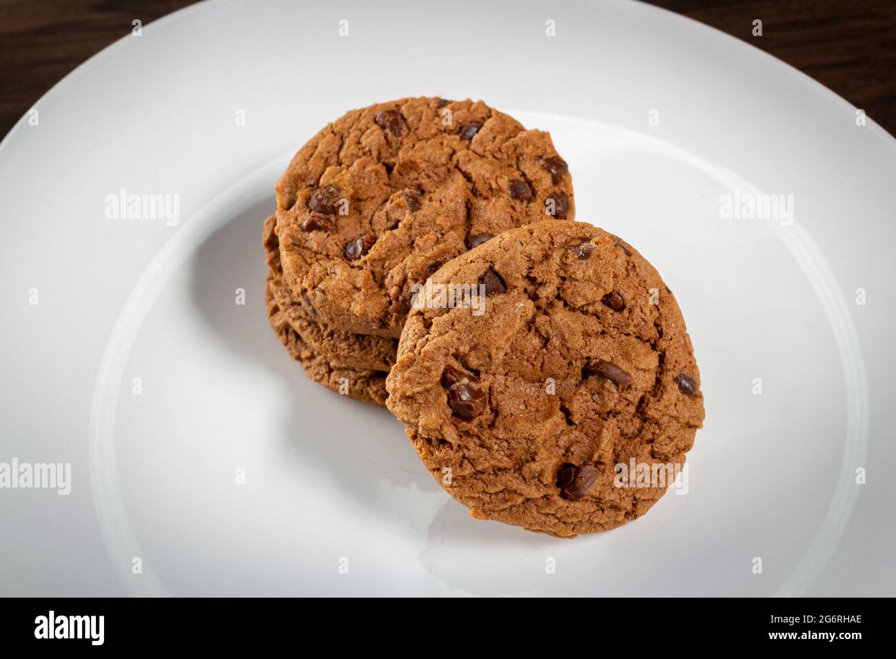 Piatto di biscotti al cioccolato appena sfornati. Sfondo in legno, fuoco selettivo Foto Stock