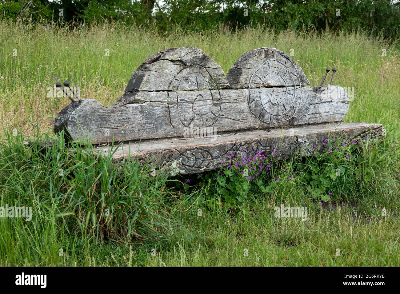 Panca insolita scavata nella forma di una lumaca nella campagna inglese Foto Stock