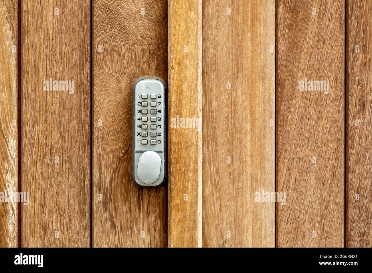 Una serratura con codice a pulsante su una porta in legno Foto Stock