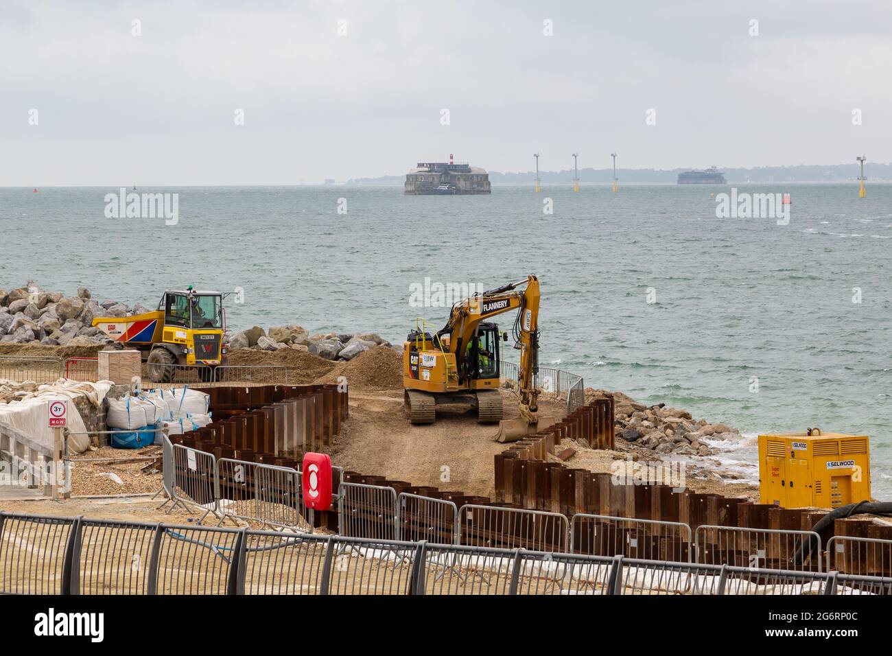 07-07-2021 Portsmouth, Hampshire, UK un escavatore e un mugnatore che lavorano sulle difese costiere a Southsea a Portsmouth con il mare sullo sfondo Foto Stock