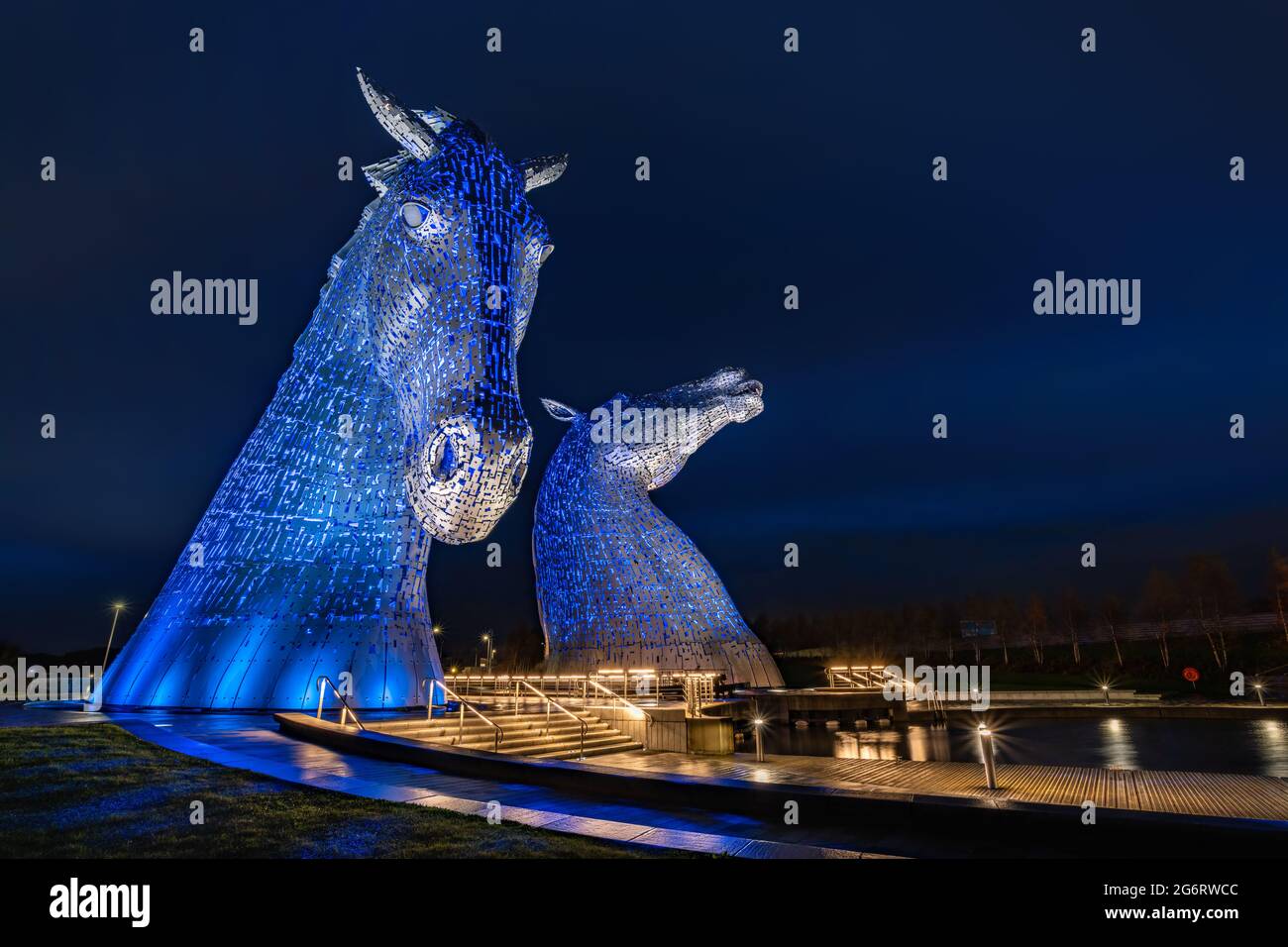 Una serata autunnale scura, bagnata e piovosa che fotografa le sculture di testa di cavallo in acciaio illuminate create da Andy Scott. Foto Stock