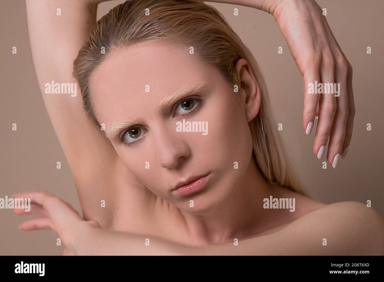 Un'immagine in vita di una giovane donna bionda con le mani vicino al viso Foto Stock