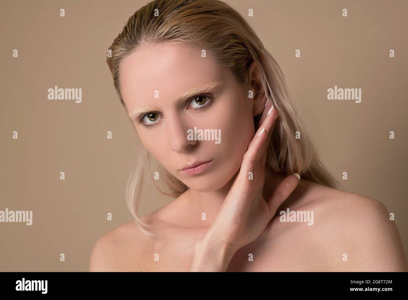 Un'immagine in vita di una giovane donna bionda con le mani vicino al viso Foto Stock
