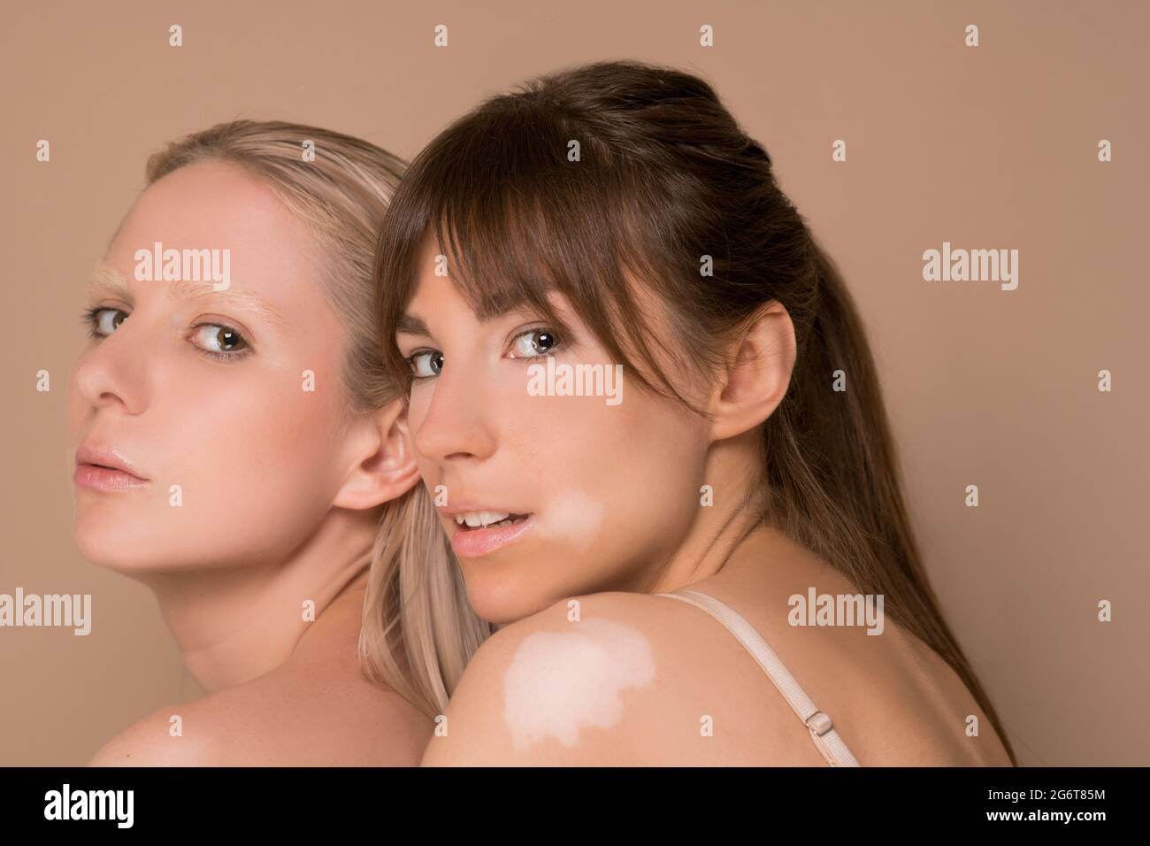 Due giovani belle donne che si levano in piedi insieme e che guardano fiduciosi Foto Stock