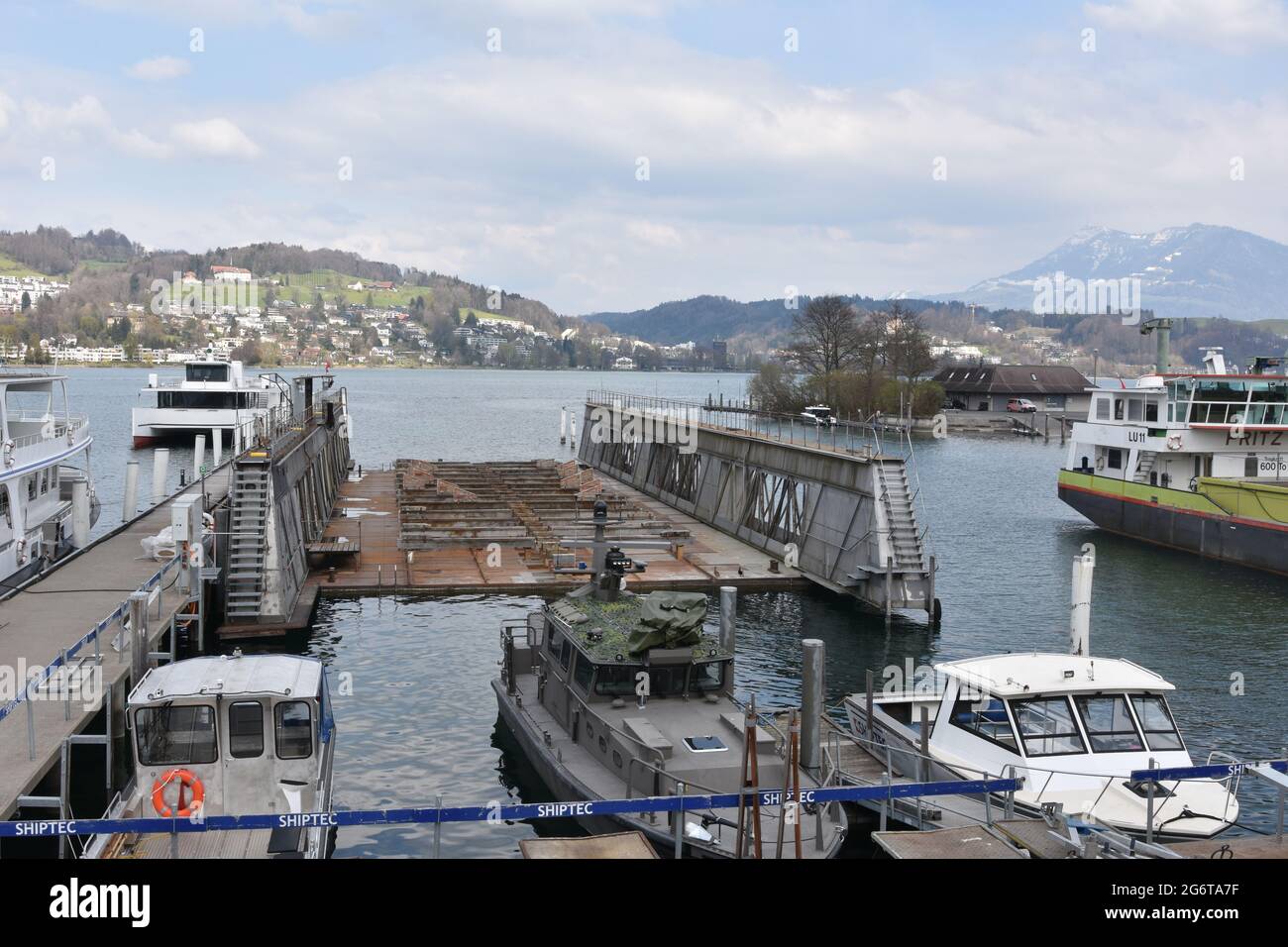 Molo galleggiante per la riparazione di navi e navi da crociera turistica sul lago di Lucerna, nel porto della città di Lucerna. Intorno sono ormeggiate piccole barche a motore. Foto Stock