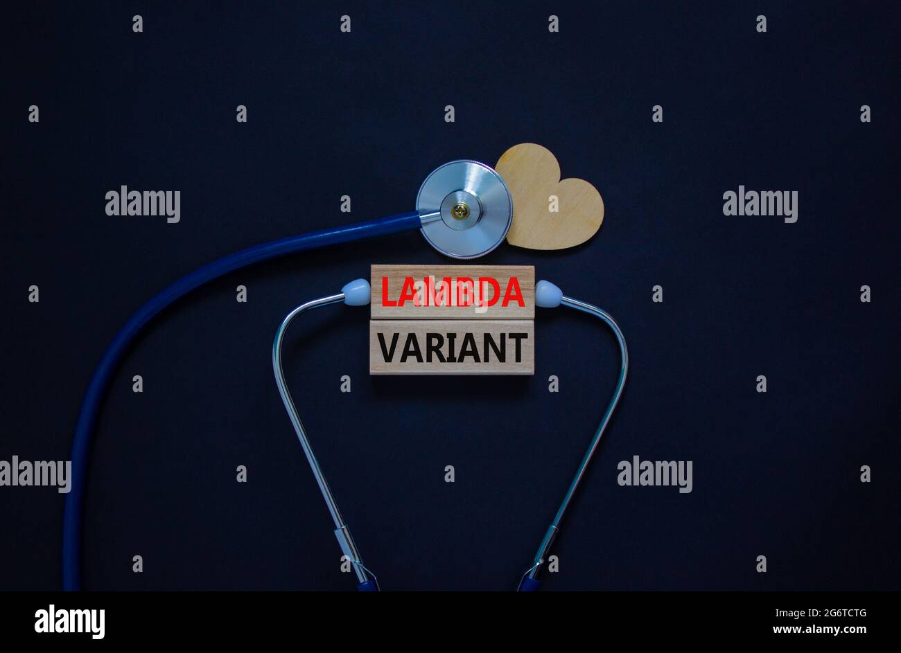 Simbolo di deformazione variante lambda Covid-19. Blocchi di legno, parole variante lambda, stetoscopio, sfondo nero. Cuore di legno. Medico e covid-19 lambda var Foto Stock