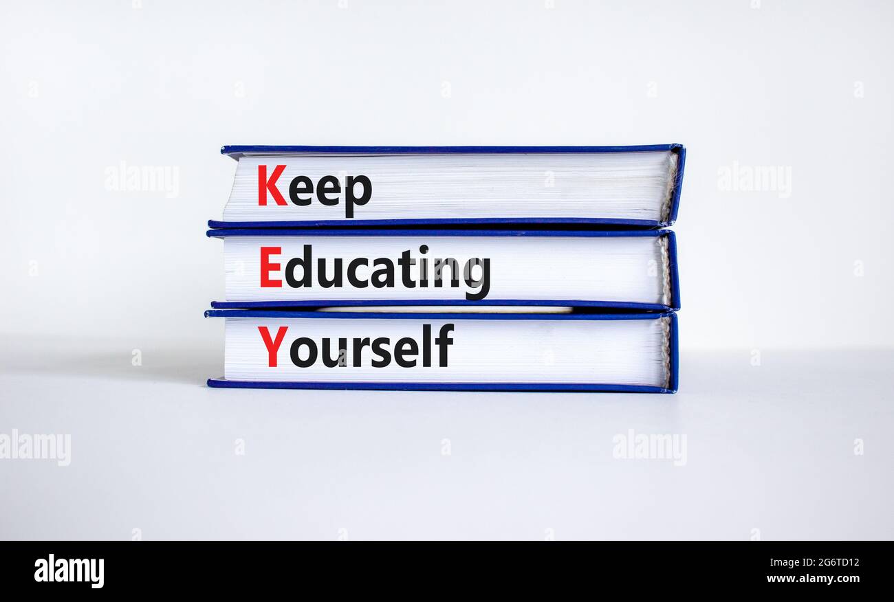 KEY, continuare a educare te stesso simbolo. Libri con parole 'CHIAVE, continuare a educare te'. Splendido sfondo bianco, spazio per la copia. Business, istruzione An Foto Stock