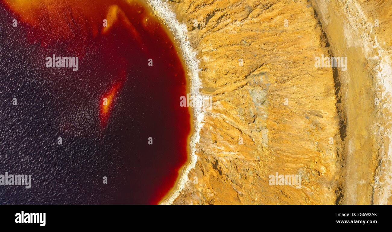 Riva di lago acido in abbandonato miniera di rame a cielo aperto, vista aerea direttamente sopra. L'acqua rossa è inquinata da acidi e metalli pesanti Foto Stock