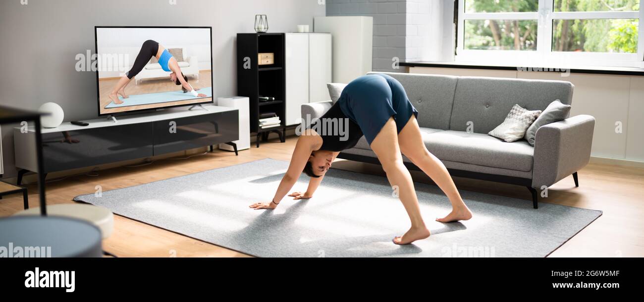 Allenamento yoga online in soggiorno. Lezioni ed esercizi per le donne Foto Stock