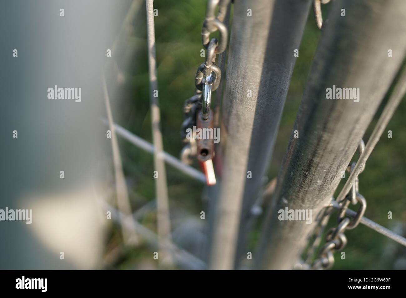 La serratura che è stata rilasciata dalla catena che ha bloccato la porta di ferro. Segno di libertà. La foto viene scattata con il bokeh in primo piano Foto Stock