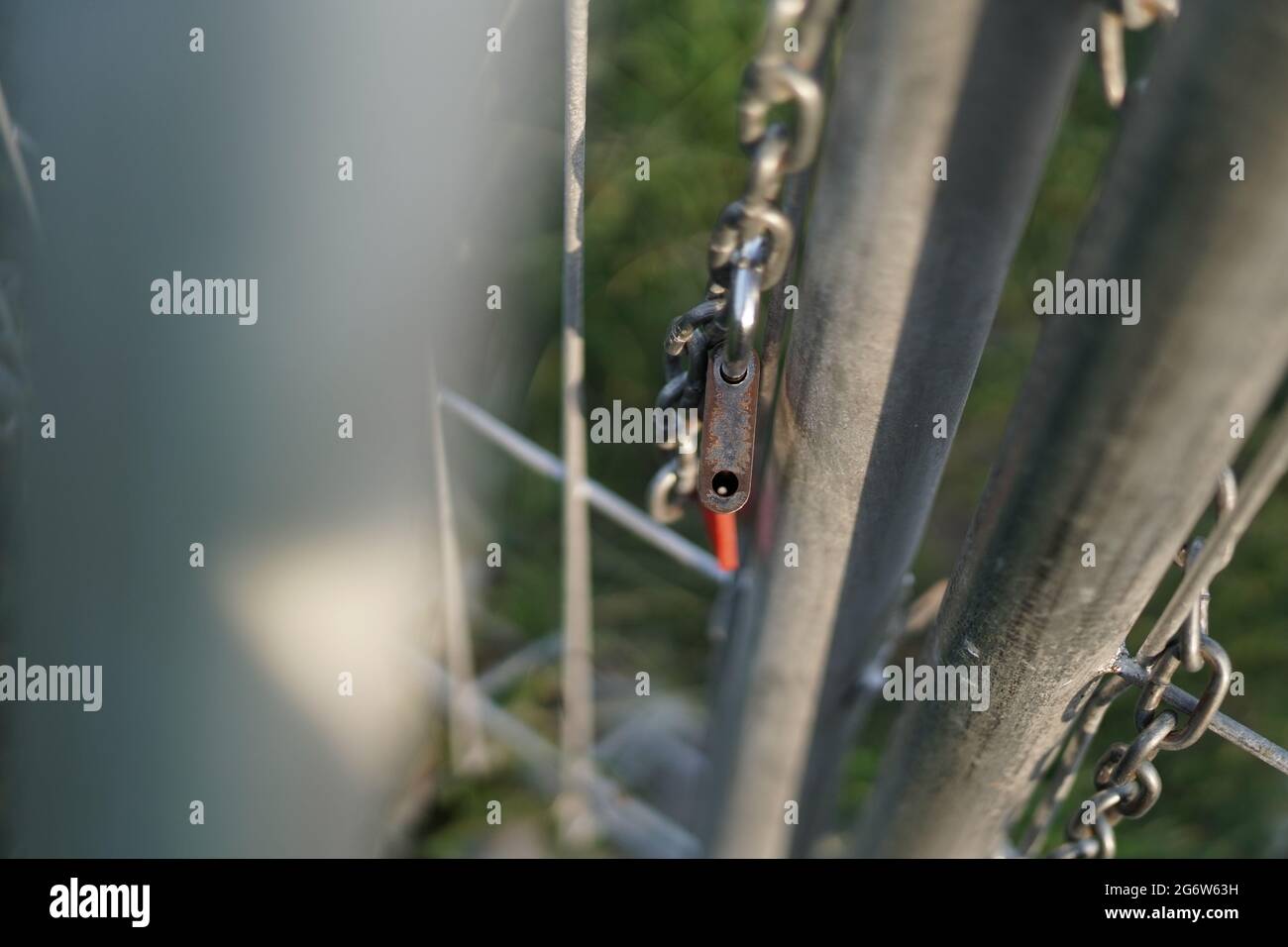 La serratura che è stata rilasciata dalla catena che ha bloccato la porta di ferro. Segno di libertà. La foto viene scattata con il bokeh in primo piano Foto Stock