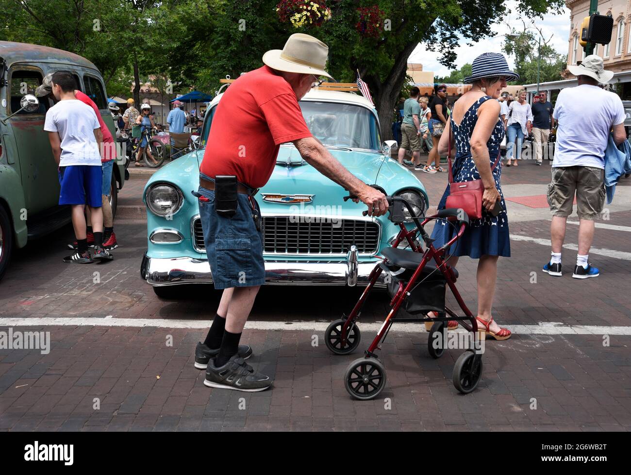 Un anziano che usa un rollator su ruote a piedi visita una mostra di auto classica a Santa Fe, New Mexico. Foto Stock