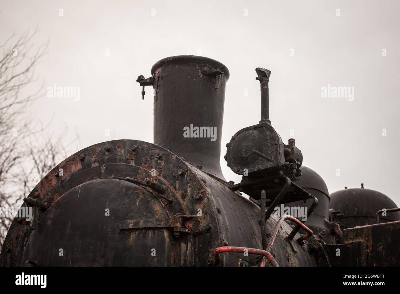Immagine di uno zoom su una locomotiva a vapore con un fuoco sul suo camino, su una locomotiva a vapore nera. Foto Stock