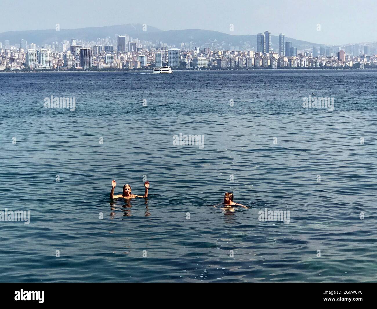 Persone che nuotano nel Mar Bosforo vicino alle Isole Principesse con il sicino di Istanbul, Turchia in background. Foto Stock