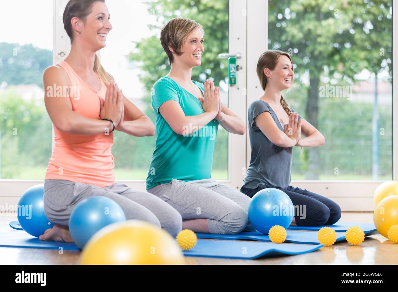 Le giovani donne a praticare lo yoga durante il recupero postnatale lezione Foto Stock