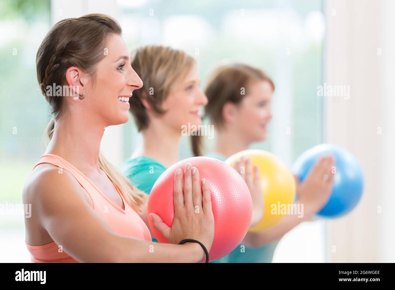 Le giovani madri che fanno yoga durante la lezione di recupero postnatale Foto Stock