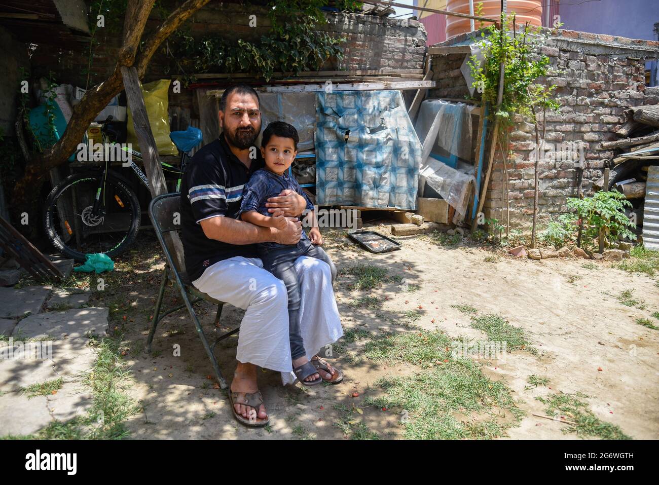 Srinagar, India. 01 luglio 2021. Bashir Ahmad Baba tiene il nipote nella sua residenza a Srinagar. Bashir Ahmad Baba, un uomo di 42 anni di Rainawari a Srinagar, è tornato a casa il 23 giugno, undici anni dopo che la polizia di Gujarat lo ha arrestato con accuse di terrore, i media locali hanno riferito. È stato prenotato in base al rigoroso illegal activities (Prevention) Act (UAPA). (Foto di Idrees Abbas/SOPA Images/Sipa USA) Credit: Sipa USA/Alamy Live News Foto Stock