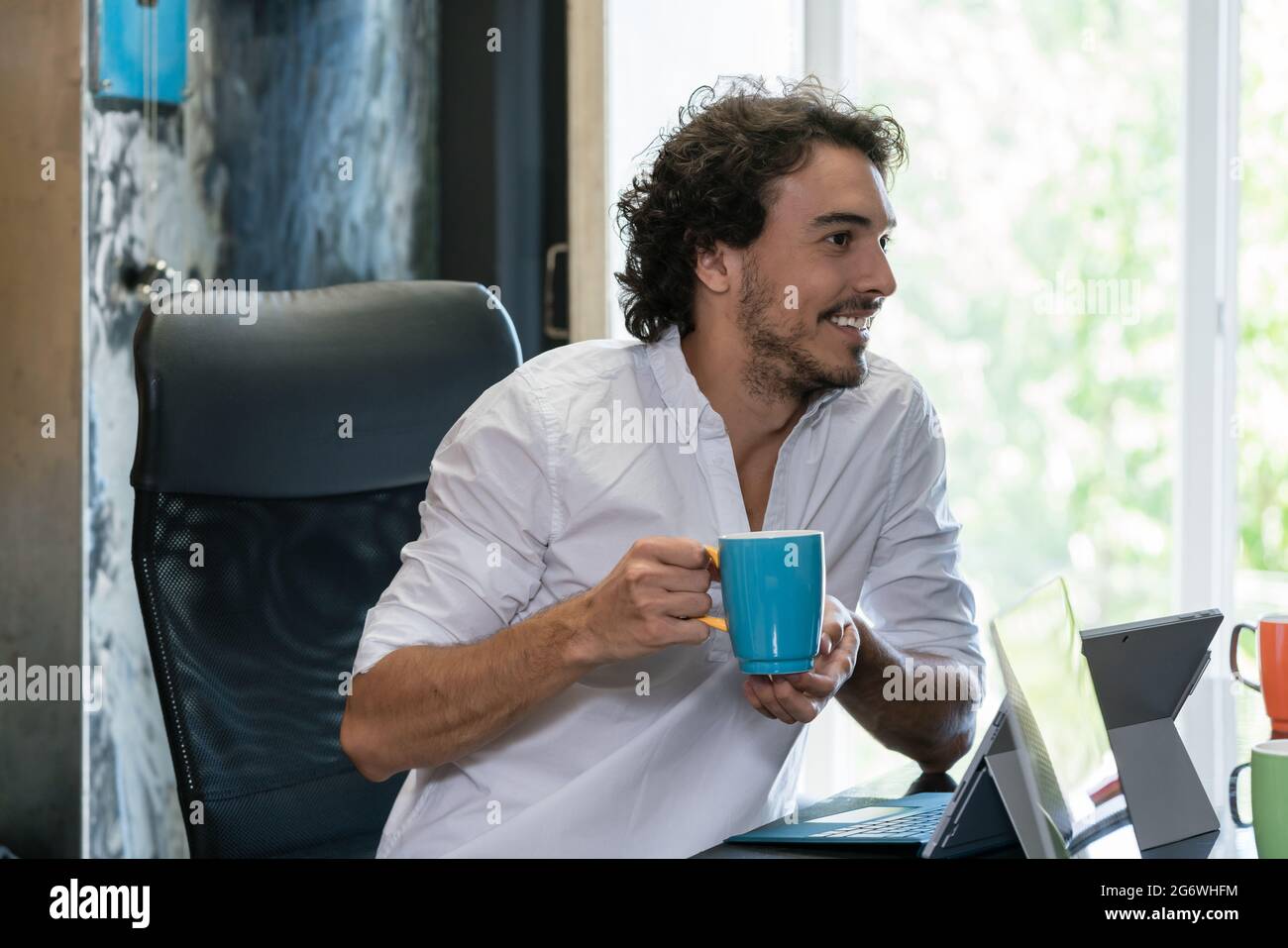 Dipendente in industrie creative con caffè e parlare Foto Stock