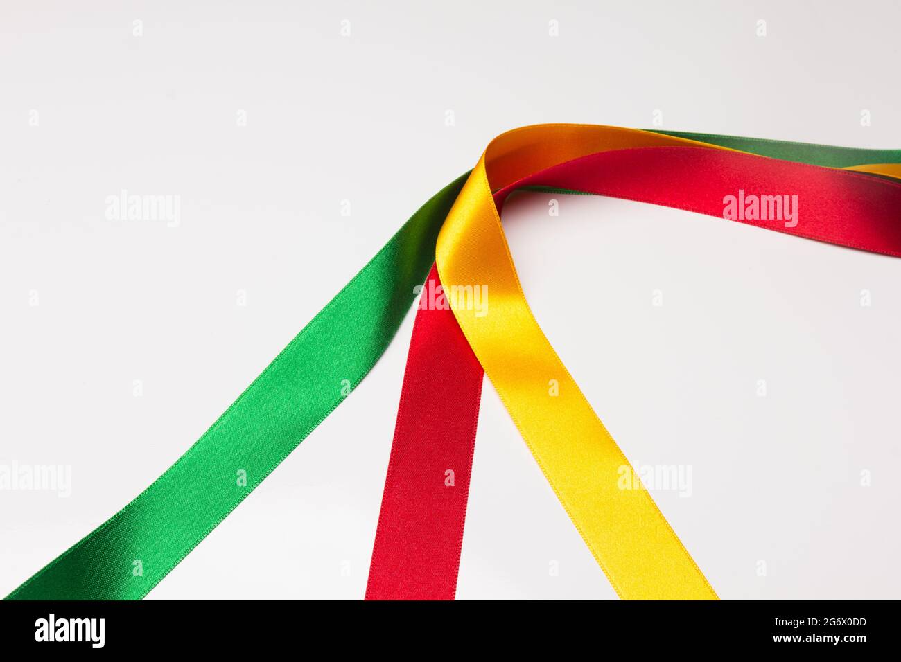 Colori di base, rosso, verde e giallo. Tessuti e nastri colorati; colori di base su sfondo bianco. Forme geometriche di strisce colorate. Foto Stock