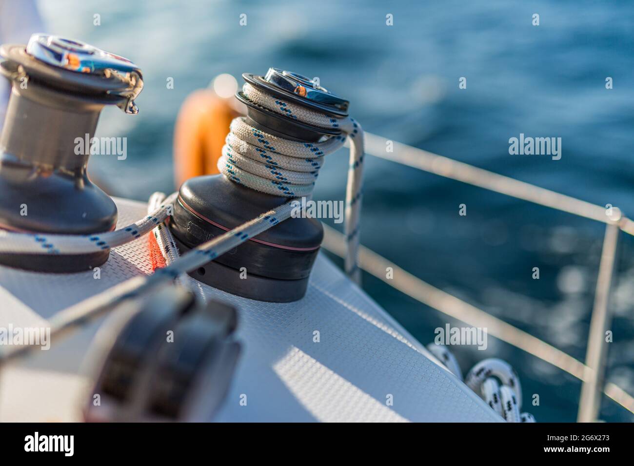 Dettagli dell'attrezzatura a vela su una barca quando si naviga in acqua in una giornata di sole. Barca a vela nel Mar Mediterraneo al tramonto, corda yacht Foto Stock