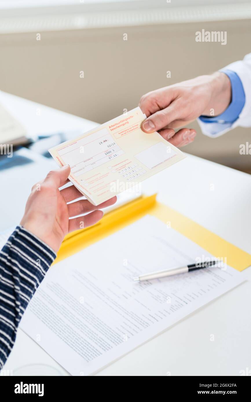 Primo piano della mano di una paziente di sesso femminile che riceve una prescrizione medica stampata dal medico primario Foto Stock