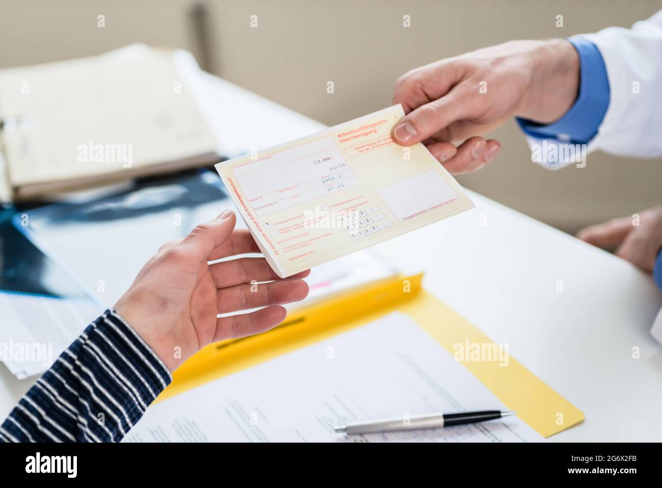 Primo piano della mano di una paziente di sesso femminile che riceve una prescrizione medica stampata dal medico primario Foto Stock