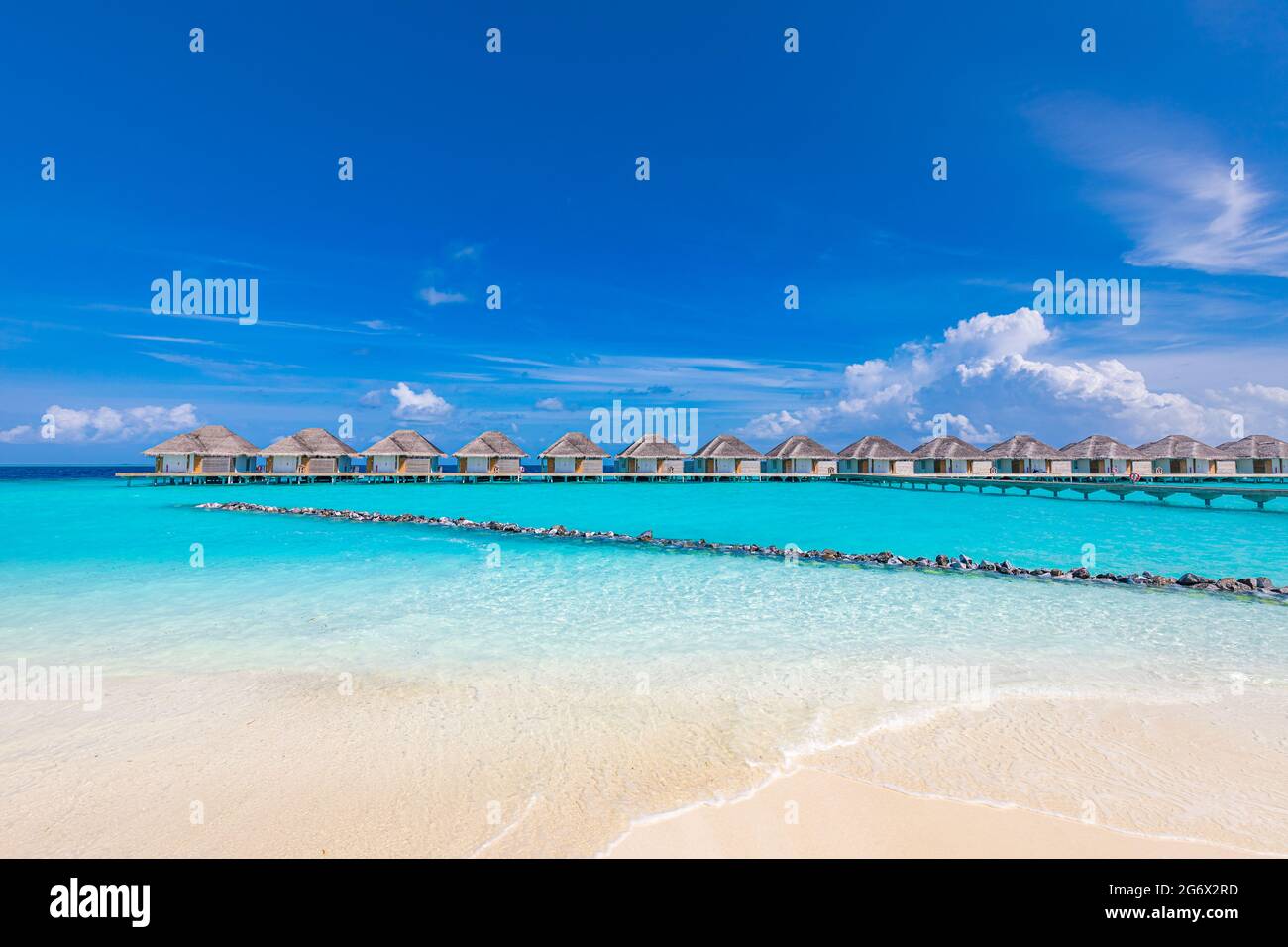 Maldive spiaggia. Panorama tropicale, resort di lusso con ville d'acqua con molo o molo in legno. Vacanza estiva e concetto di viaggio. Isola Paradiso Foto Stock