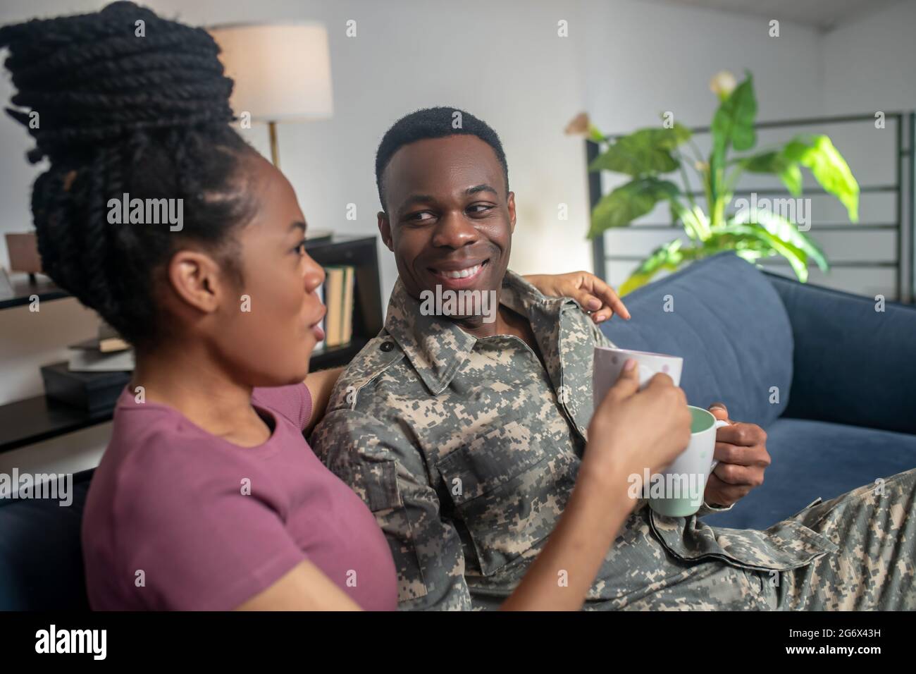 Gioiosa socializzante donna e bevitori militari di caffè Foto Stock