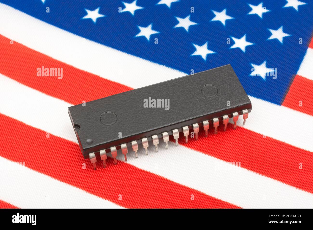 Immagine ravvicinata del circuito integrato / chip EPROM su una piccola bandiera statunitense Stars & Stripes. Per le Start-up di semiconduttori statunitensi, la supremazia dei chip americani. Foto Stock