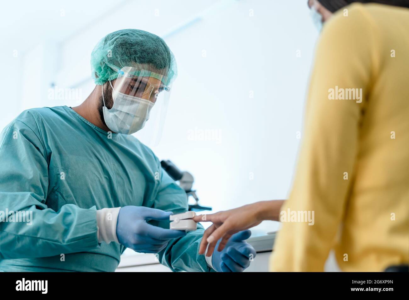 Operaio medico che esamina l'ossigenazione alla paziente di sesso femminile con il nuovo ossimetro dispositivo durante l'epidemia di virus corona Foto Stock