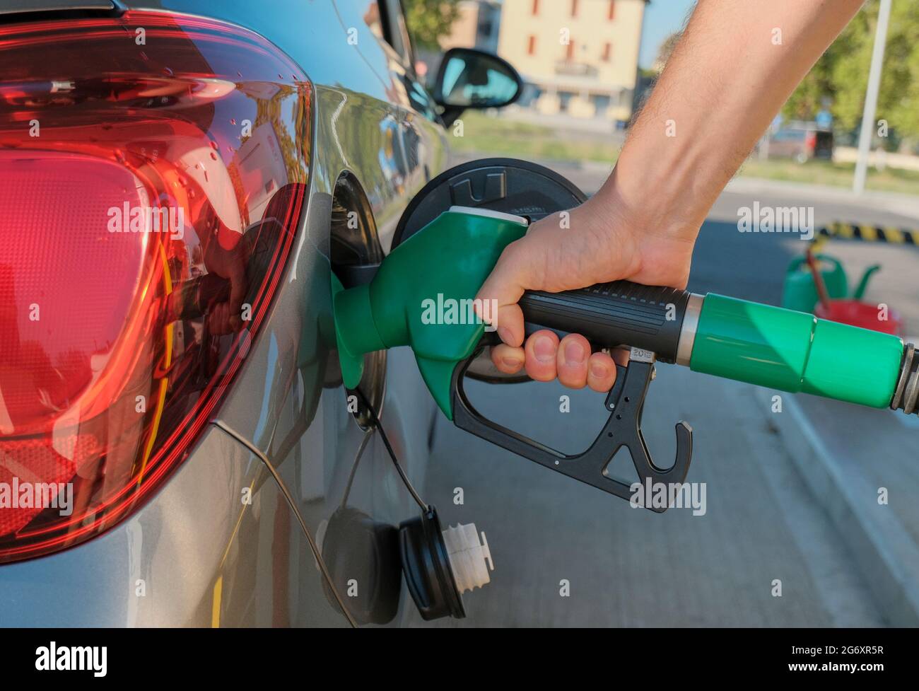 Mani dell'uomo che tengono la pompa del gas e riempiono l'auto di carburante da vicino. Industria energetica. Stazione di benzina business / mercato. Foto Stock