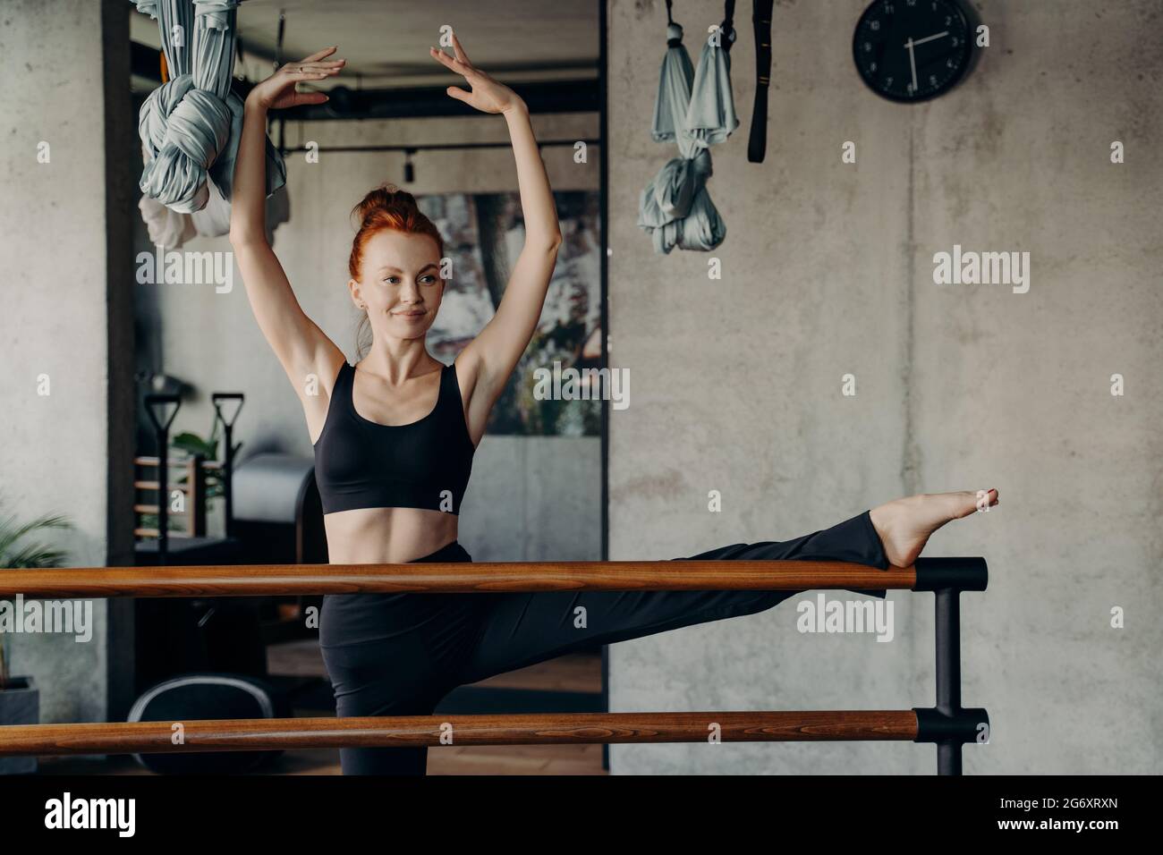 Giovane donna sorridente che ama l'allenamento di barre in studio Foto Stock