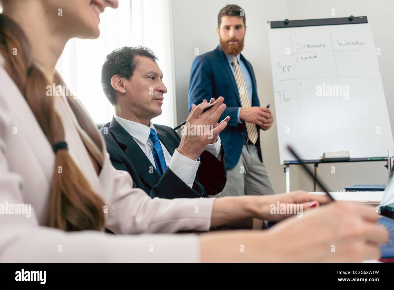 Esperto affidabile indossando formale di business suit durante la conduzione di una analisi SWOT durante la riunione del consiglio di amministrazione in una sala conferenze di un successo Foto Stock