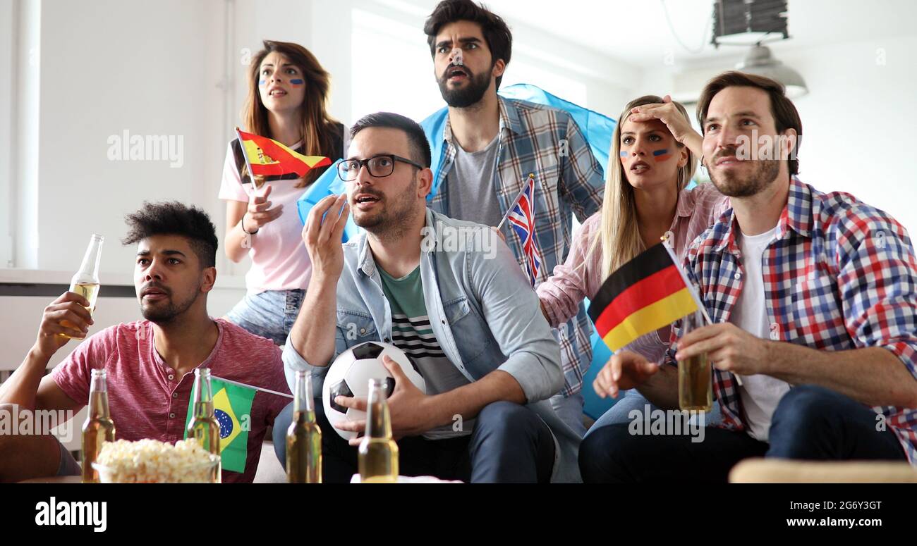 Gruppo di Tifosi delusi e felice di guardare una partita di calcio sul lettino. Foto Stock