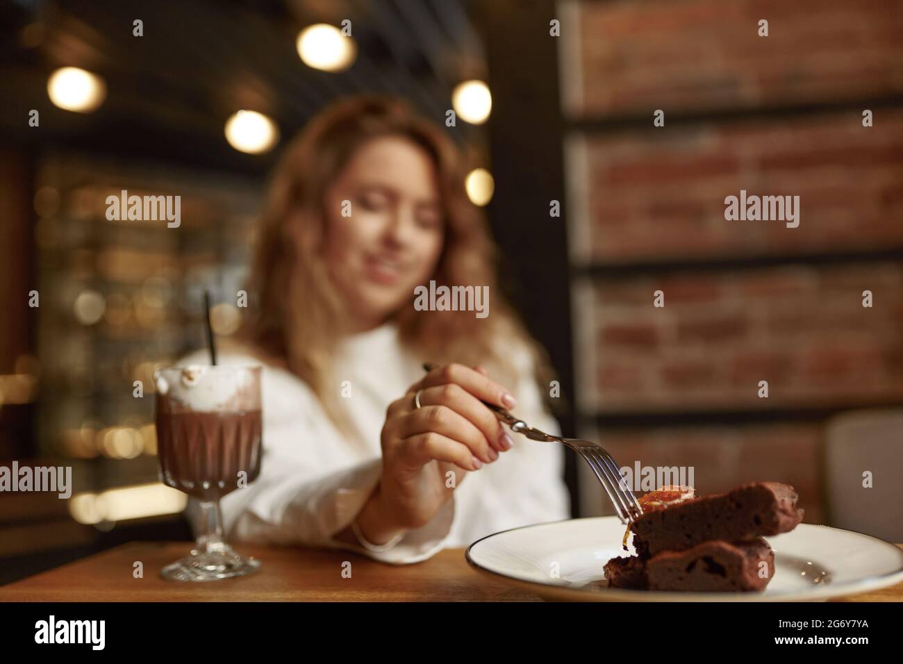 Bella donna che mangia cioccolato e bere caffè Foto Stock