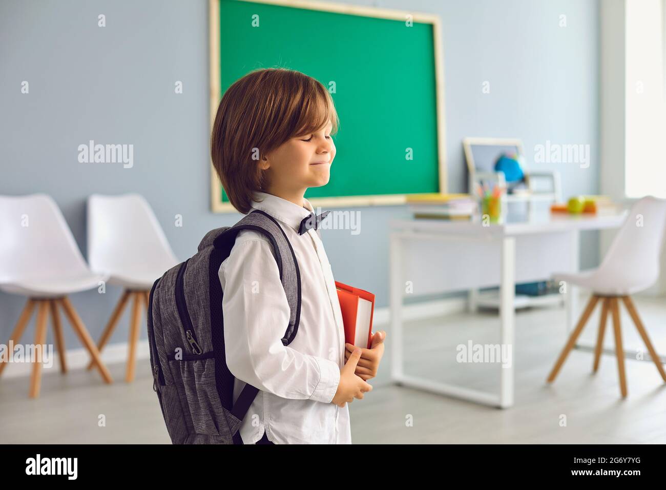 Torna a School.Happy scolaro con zaino sorridente in classe. Foto Stock