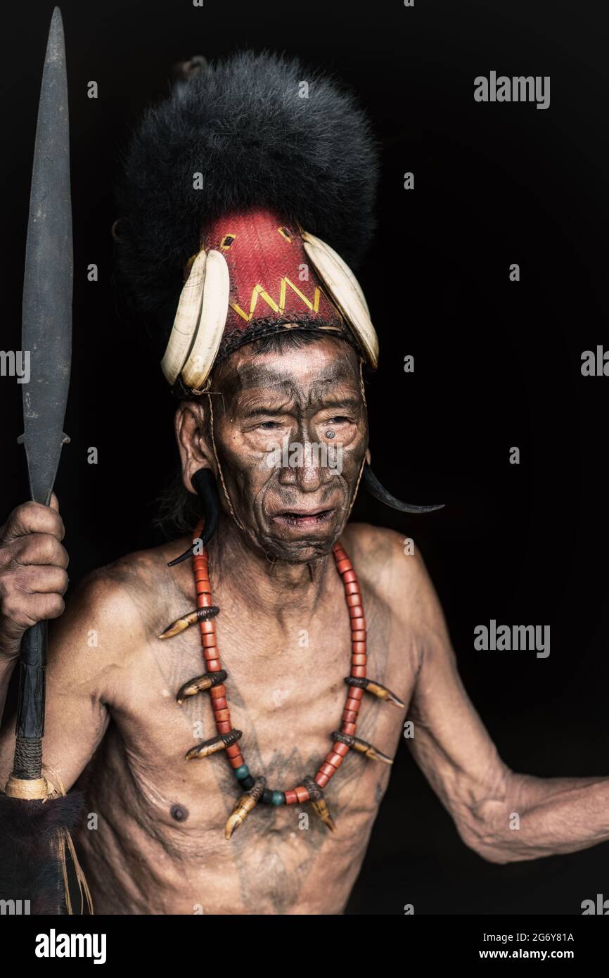 Un tribesman Konyak con un headdress e lancia. DONEGAL, IRLANDA: Ritratti NOTEVOLI hanno catturato i volti degli ultimi membri di un antico indiano Foto Stock
