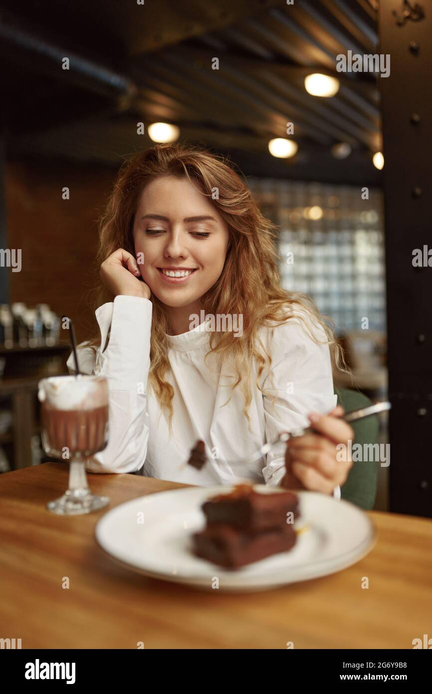 Donna che passa del tempo libero al caffè con torta e caffè Foto Stock