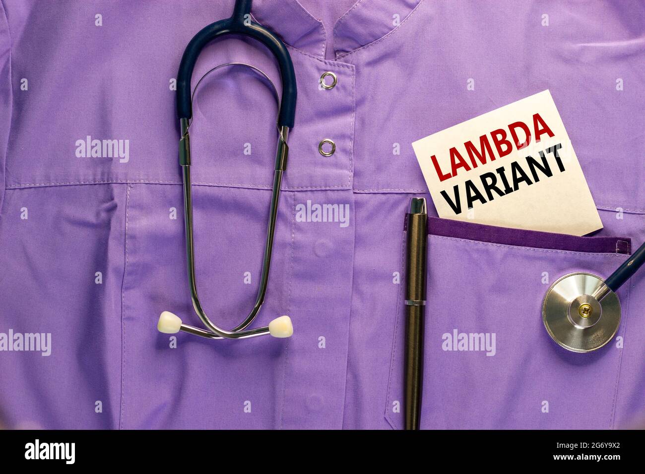 Simbolo della variante lambda Covid-19. Uniforme medica, cartoncino bianco con parole 'variante lambda', penna metallica e stetoscopio. Medico e COVID-19 pandemia la Foto Stock