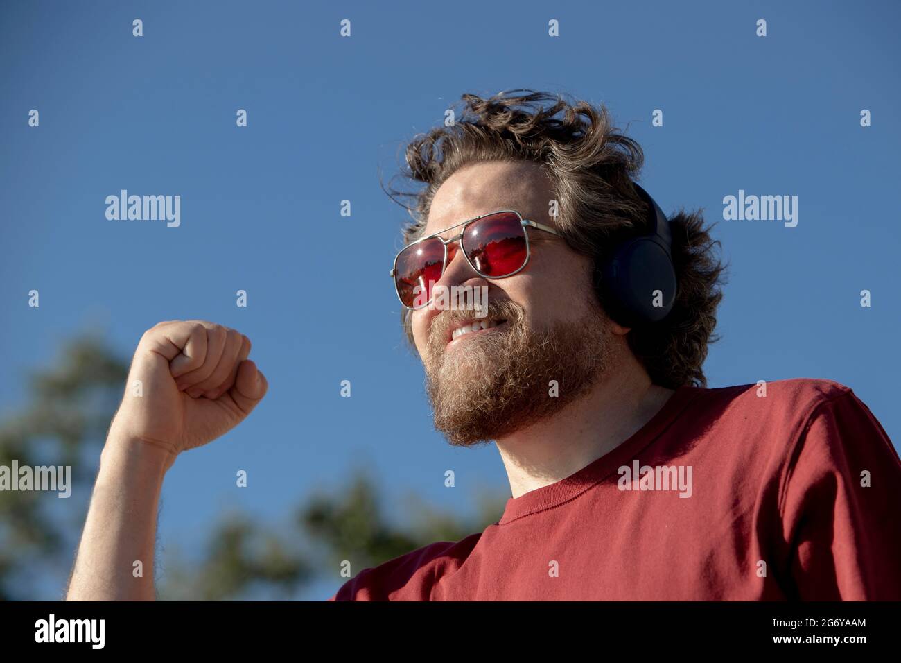 Uomo caucasico con barba e alzando il pugno con un'espressione di successo Foto Stock