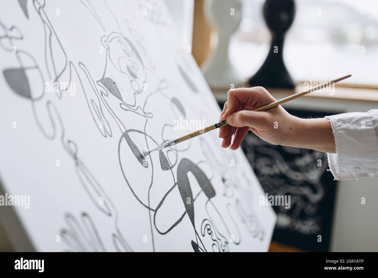Primo piano di pittura femminile a mano con pennello su tela Foto Stock