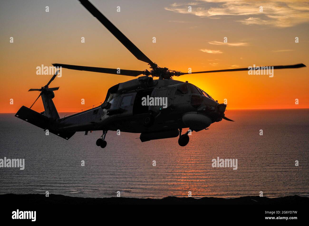 Un ritratto air-to-air di un elicottero Sikorsky S70B Seahawk della Marina australiana al tramonto Foto Stock