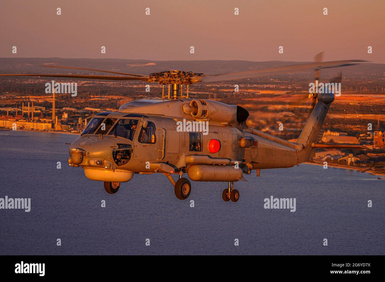 Un ritratto air-to-air di un elicottero Sikorsky S70B Seahawk della Marina australiana al tramonto Foto Stock