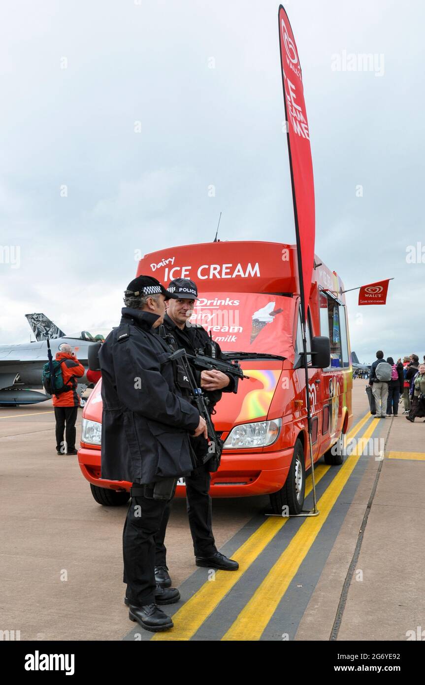 La polizia britannica armata apparentemente custode un pulmino gelato al Royal International Air Tattoo Airshow. Posizionamento umoristico, fornendo al contempo la sicurezza degli eventi Foto Stock
