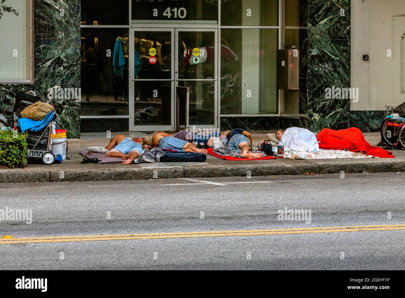 La mattina presto, i senzatetto dormono sui marciapiedi del centro di San Pietroburgo, Florida. Foto Stock