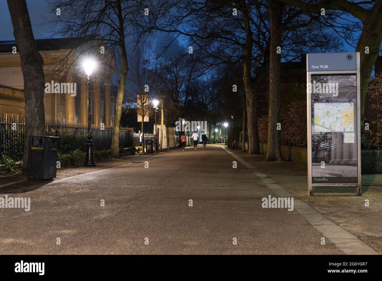 New Walk Museum sulla sinistra di notte, la gente in fondo va in lontananza. Luce di strada luminosa di notte, con un cartello turistico. Foto Stock