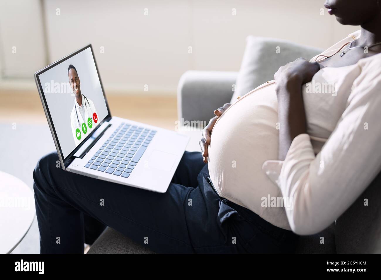 Video chiamata del medico delle donne africane incinte sul laptop a casa Foto Stock