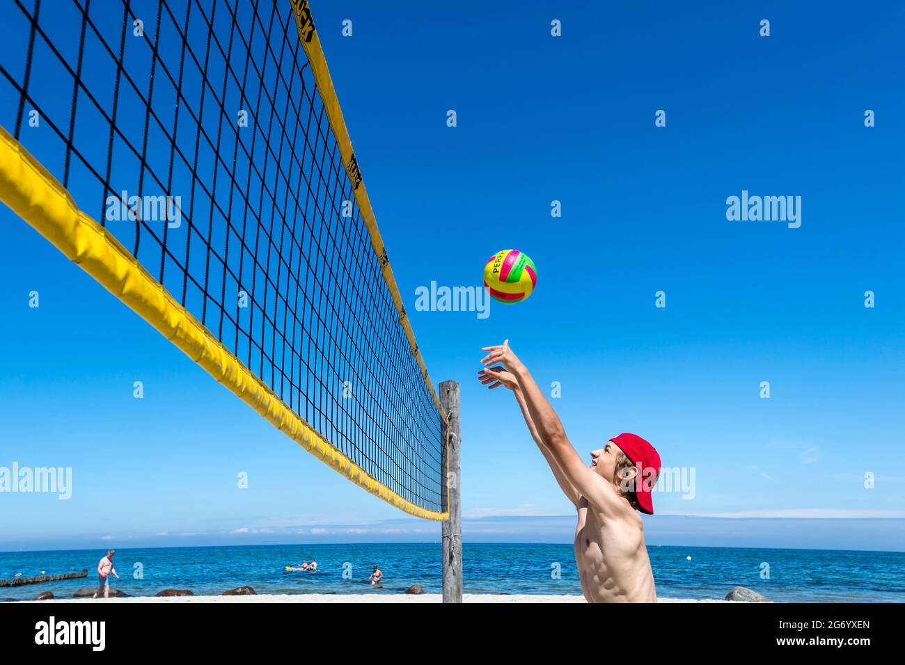 Il ragazzo sportivo gioca a Beach volley a Ost See in una giornata di sole Foto Stock